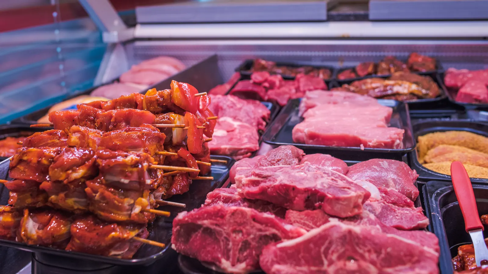 Steaks und marinierte Fleischspieße in der Fleischtheke
