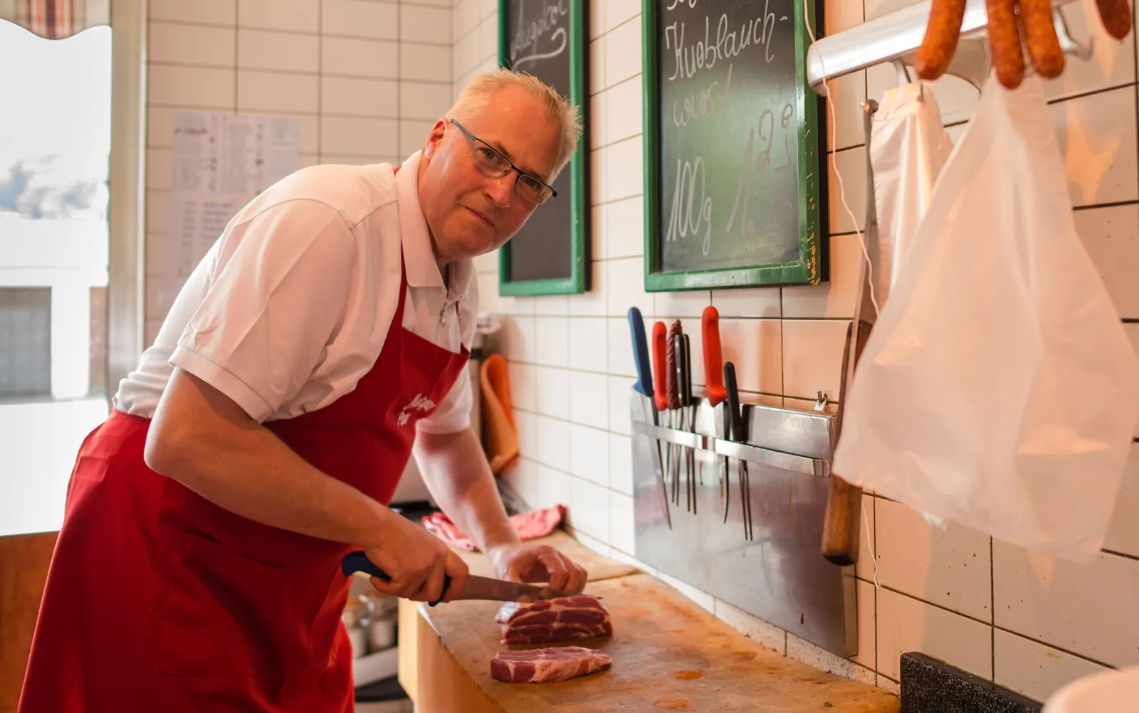 Fleischermeister Michael Engels schneidet ein Stück Fleisch zu